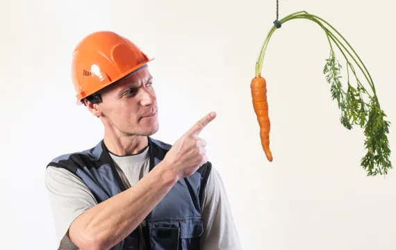 Safety worker pointing to carrot on a stick