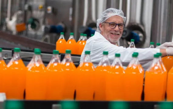 Conveyor belt with orange drinks being produced
