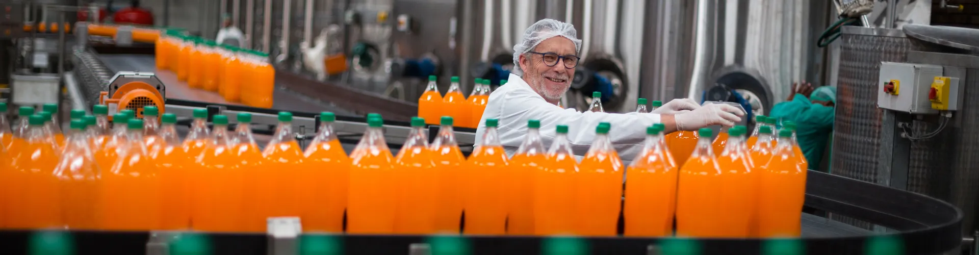 Conveyor belt with orange drinks being produced
