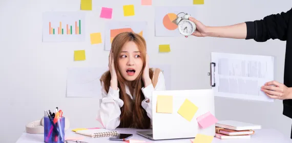 Young worker being pressured by a manager holding a clock