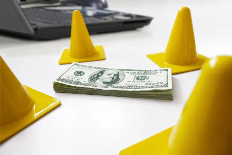 Safety cones surrounding a stack of money