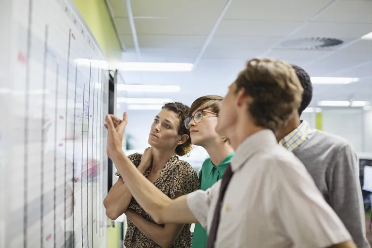 Team looking at work whiteboard
