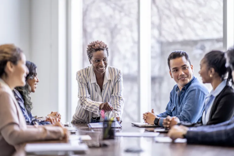 Leader at a conference table with employees